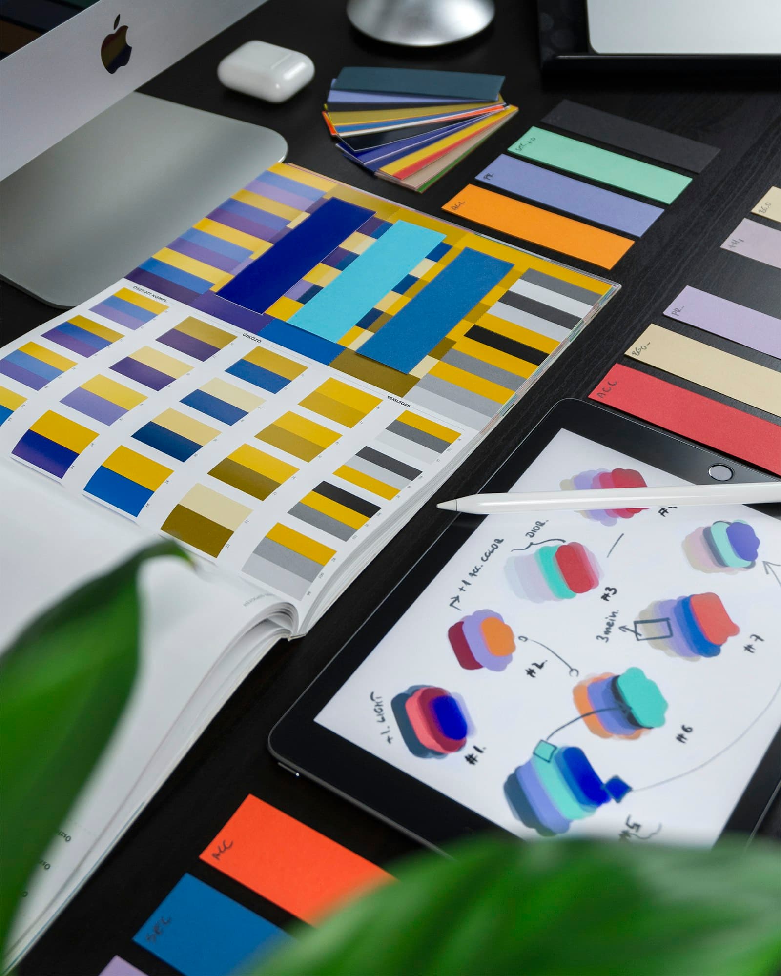 An open color-reference book showing a palette of swatches — the kind of decisions behind the Wix design language.