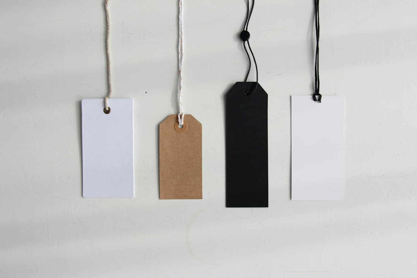 A small stack of plain paper price tags arranged on a neutral surface — the simplest possible billing artifact.